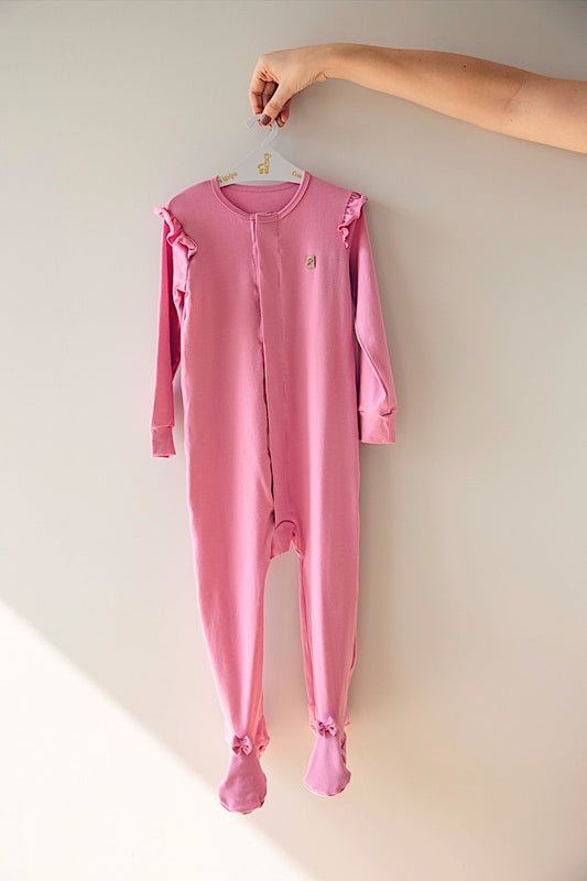 LEVES DEFEITOS - MACACÃO MAGNÉTICO ROSA COM BABADO E LAÇO