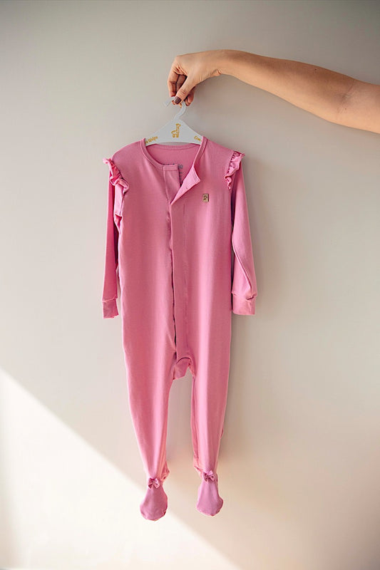 LEVES DEFEITOS - MACACÃO MAGNÉTICO ROSA COM BABADO E LAÇO