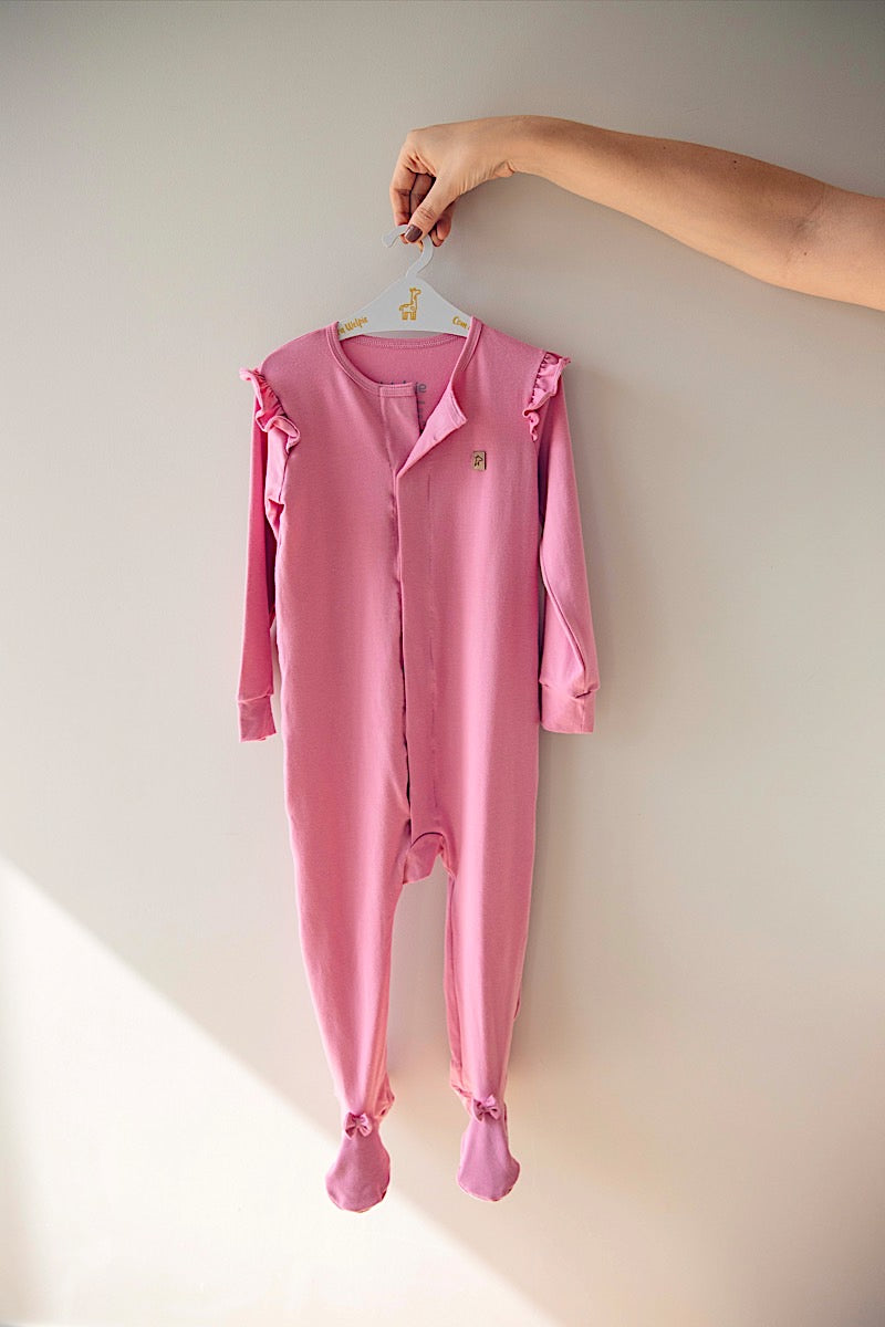 LEVES DEFEITOS - MACACÃO MAGNÉTICO ROSA COM BABADO E LAÇO